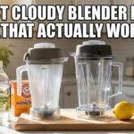 A cloudy blender pitcher next to a clear one on a kitchen counter with vinegar and baking soda, showing a cloudy blender pitcher fix.