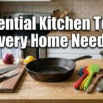 A wooden kitchen counter showing the essential kitchen tools every home needs, like a cast iron pan, knives, and mixing bowls.