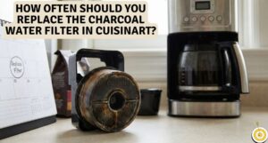 Used Cuisinart charcoal water filter in black plastic holder sitting on kitchen counter next to a calendar marked replace filter and a coffee maker.