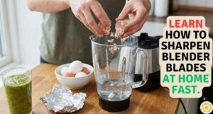Close-up of hands crushing eggshells into a glass blender pitcher with water to demonstrate how to sharpen blender blades at home using the eggshell hack.