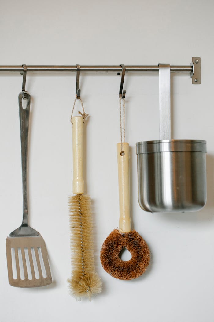 my-steps Diverse kitchen utensils including brush and stainless tools on wall hanger.
