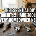 A flathead screwdriver, Phillips screwdriver, pliers, wire cutters, and a claw hammer laid out on a wooden workbench representing Essential DIY Tools for every home.