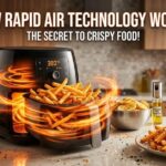 A black modern air fryer in a kitchen showing a glowing orange vortex of hot air circulating around crispy French fries.