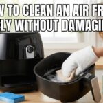 Person gently cleaning a black air fryer basket with a soft soapy cloth on a kitchen counter, featuring the text "How to Clean an Air Fryer Safely Without Damaging It."