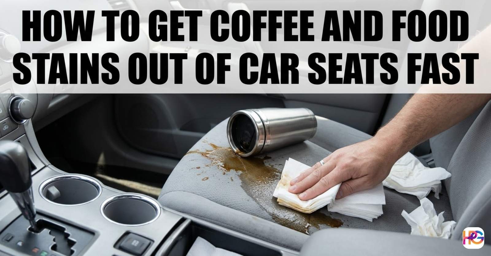 A hand blotting a fresh coffee spill on a gray cloth car seat using white paper towels next to a tipped-over silver travel mug.