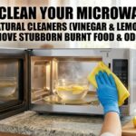 A person cleaning an open microwave with a yellow cloth and blue gloves. A glass bowl of steaming lemon water is inside. Bottles of vinegar and baking soda sit on the kitchen counter nearby.