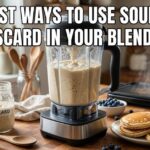 A blender sits on a kitchen counter with sourdough batter inside. A jar of discard and a plate of waffles are next to it. Text on the image says 5 Best Ways to Use Sourdough Discard in Your Blender.