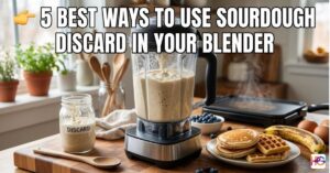 A blender sits on a kitchen counter with sourdough batter inside. A jar of discard and a plate of waffles are next to it. Text on the image says 5 Best Ways to Use Sourdough Discard in Your Blender.