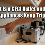 A person pressing the reset button on a kitchen GFCI outlet next to a stainless steel deep fryer, with text reading What Is a GFCI Outlet and Why Your Appliances Keep Tripping It.