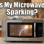 A close-up view of an open microwave oven in a kitchen with a bright blue electrical spark arcing near a greasy waveguide cover on the interior side wall.