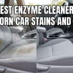 A person spraying an enzyme cleaner for car upholstery onto a stained gray fabric seat to remove deep organic odors.