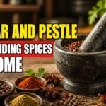 Best mortar and pestle for grinding spices at home, shown with whole and ground spices on a rustic kitchen table.