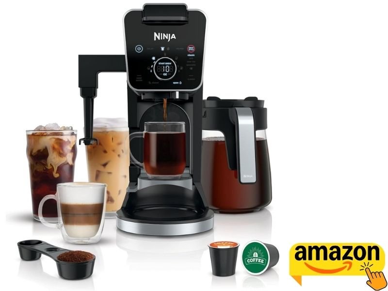 Ninja DualBrew Pro Specialty Coffee System in black and silver, dispensing coffee into a clear glass mug alongside iced and foamed drinks, a glass carafe, coffee pods, and a scoop.
