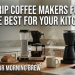A wide 1200x627 image of a modern kitchen counter featuring top-tier drip coffee makers for 2026, including a silver Moccamaster, a matte black Fellow Aiden, and a white Café Specialty brewer. The image includes a steaming mug of coffee and fresh sourdough bread. Large white Impact font text reads: "TOP 5 DRIP COFFEE MAKERS FOR 2026: PICK THE BEST FOR YOUR KITCHEN" and "UPGRADE YOUR MORNING BREW."