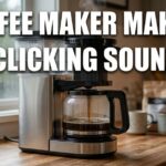 A stainless steel drip coffee maker brewing coffee on a wooden counter with the bold text coffee maker making clicking sound.