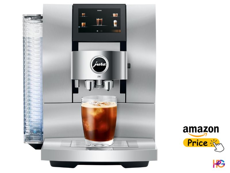 A front-facing studio image of a silver Jura Z10 automatic coffee machine on a white background. It features a modern design with a large touchscreen display at the top, showing various drink icons. An iced coffee drink with full crema and ice cubes is centered in a tall glass beneath the spouts. The rippled glass water tank on the left is illuminated.