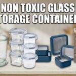 A header image for a guide to glass food storage containers, featuring the text 'BEST NON TOXIC GLASS FOOD STORAGE CONTAINERS' above a selection of container types: two tall Weck tulip jars on the left, a mixed stack of rectangular and round Glasslock containers in the center, and a set of navy blue Caraway ceramic-coated containers on the right.