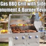 A 4-burner Monument natural gas bbq grill with side burner open and cooking food on a backyard patio with people in the background.