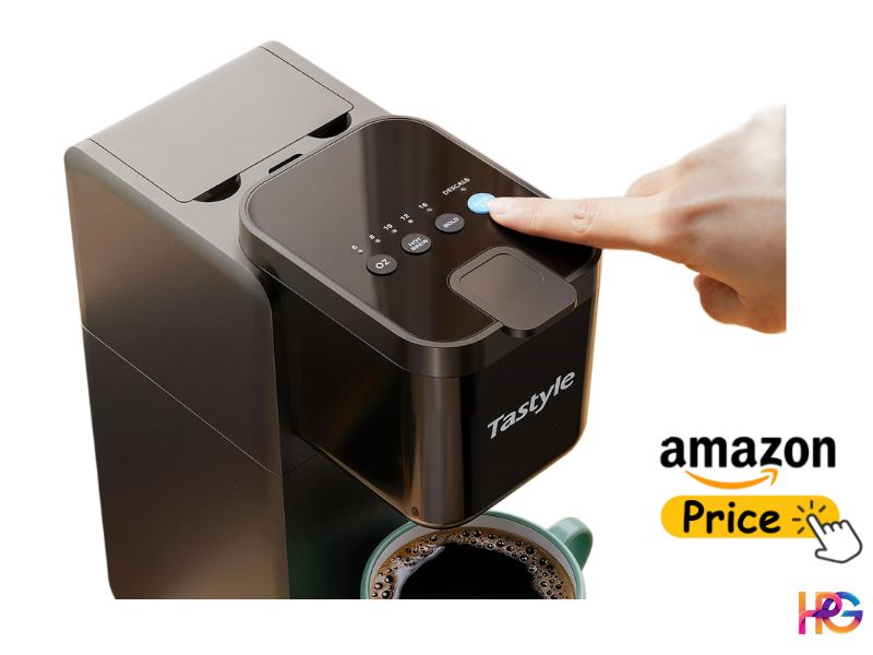 A close-up view of the control panel on the top of the black Tastyle coffee maker. A user's index finger is pressing a blue, circular button labeled 'DESCALE.' A mug of hot coffee is partially visible in the foreground.