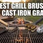 Four different styles of premium grill brushes arranged horizontally on a rustic wooden table next to an active, fiery backyard grill with cast iron grates. The text 'BEST GRILL BRUSH FOR CAST IRON GRATES' is displayed prominently across the top in a bold, white Impact font.