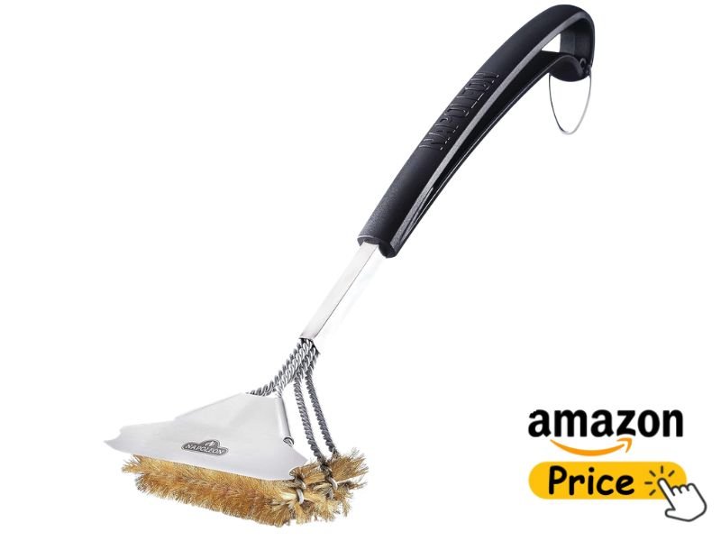 A Napoleon brand brass bristle grill brush featuring a long black handle and an attached metal scraper plate, displayed with an Amazon price button icon.