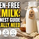 Gluten-free oat milk in a glass with rolled oats and a bottle labeled gluten-free.